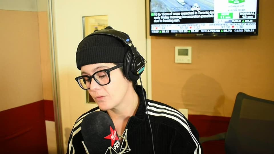 A photo of Jax Irwin behind the microphone in a radio studio.