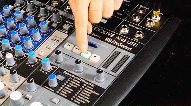 Image shows someone pressing the play/pause button on a PreSonus StudioLive AR8 USB Mixer